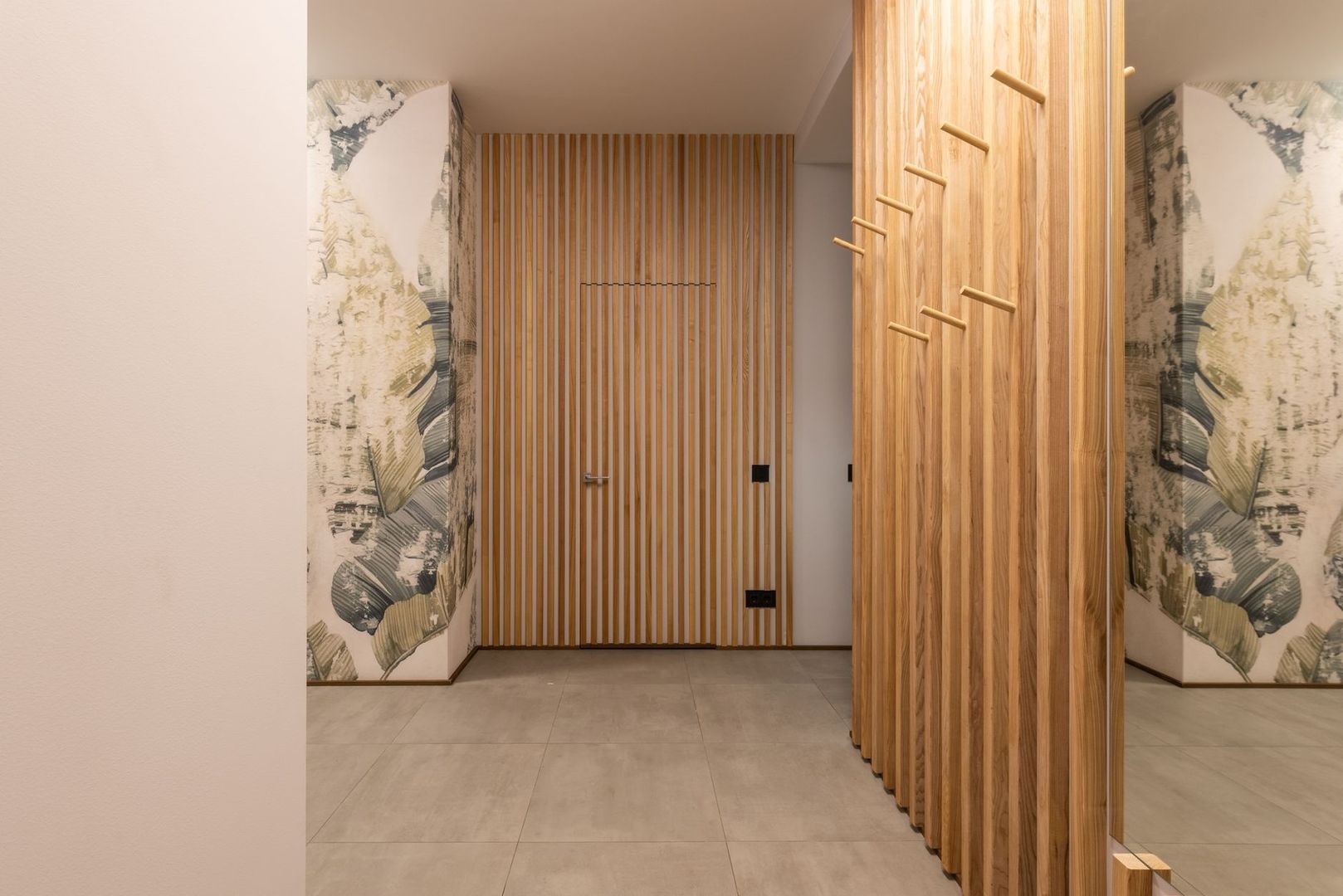 Elegant hall med ribbvägg, träpanel, spegel och mönstrad tapet